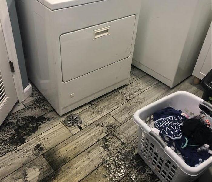 Left over dirt and debris in a laundry room from a recent flood