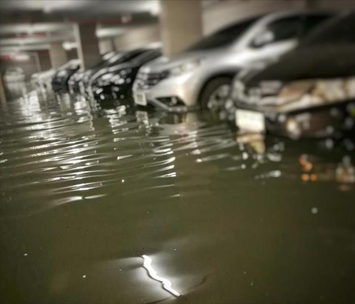 Cars in black flood water in a parking garage
